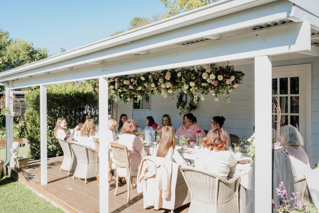 A beautiful backyard birthday party with a beautiful floral ceiling installation.