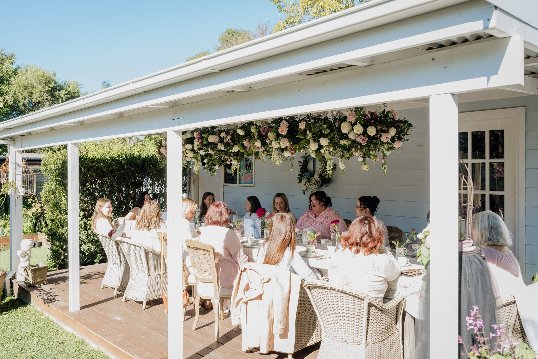 A beautiful backyard birthday party with a beautiful floral ceiling installation.